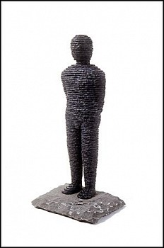 Boaz Vaadia Zevulun (#25) (1995), bronze and bluestone sculpture, 21 x 10 x 8 inches. A layered stone human figure standing on a natural stone base, symbolizing Vaadiaâ€™s connection to nature, timeless human form, and the organic process of sculptural crea