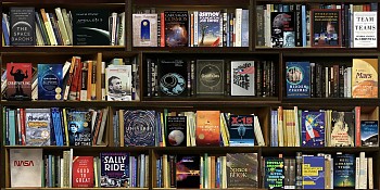 Photographic artwork titled Space (2021) by Max-Steven Grossman, a diasec-mounted fine art print (Edition 1/5, 37 x 75 in.), featuring a hyperreal bookshelf composition with books on space exploration, NASA, astrophysics, and interstellar travel.